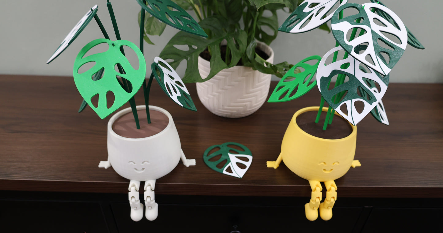 Two plant-shaped figurines with leaf designs on a wooden surface.