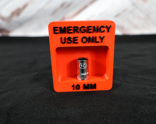 Red container labeled 'Emergency Use Only' with a 10mm object inside on a black background
