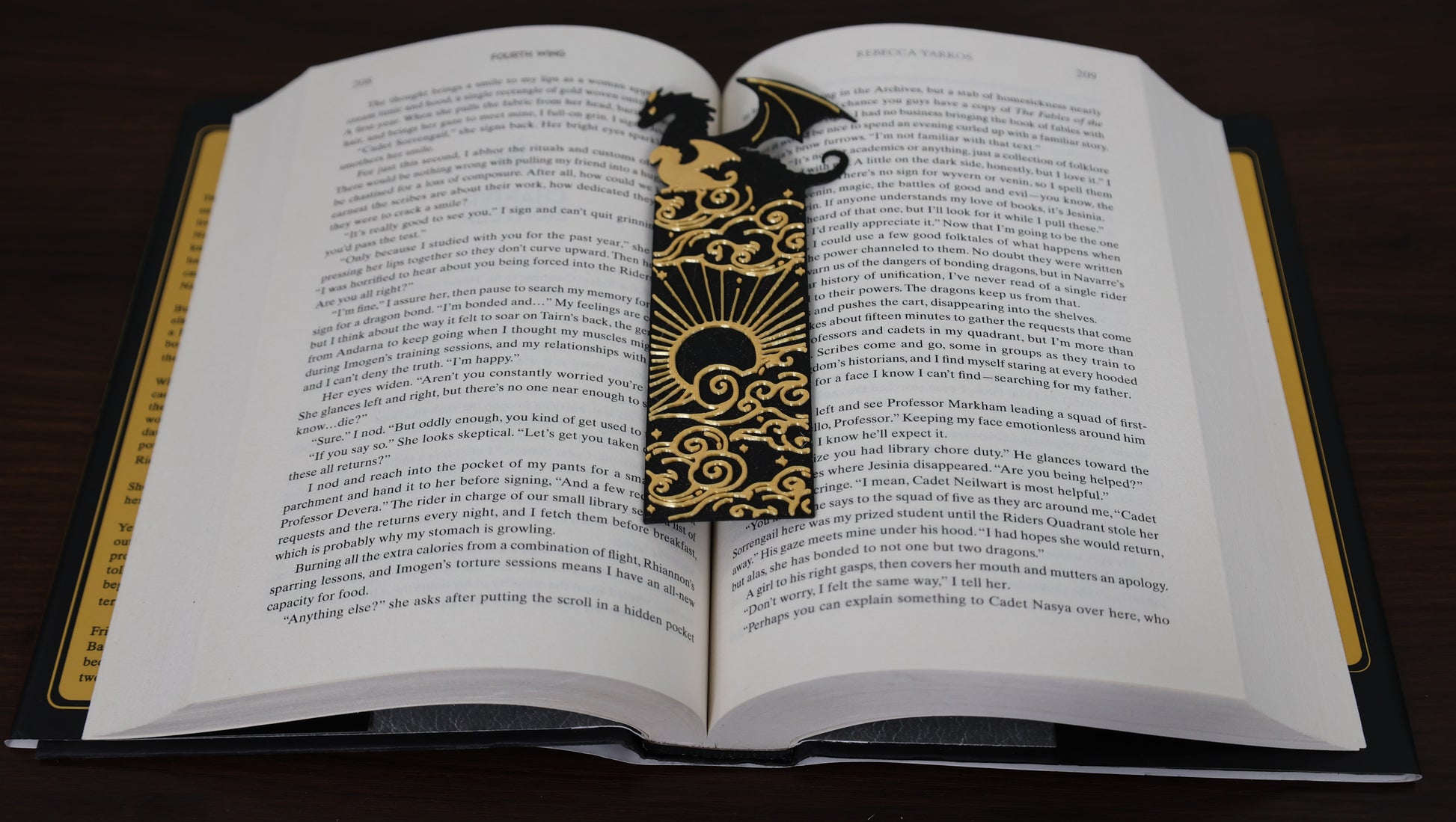 Open book with a decorative bookmark featuring a dragon design on a dark surface.